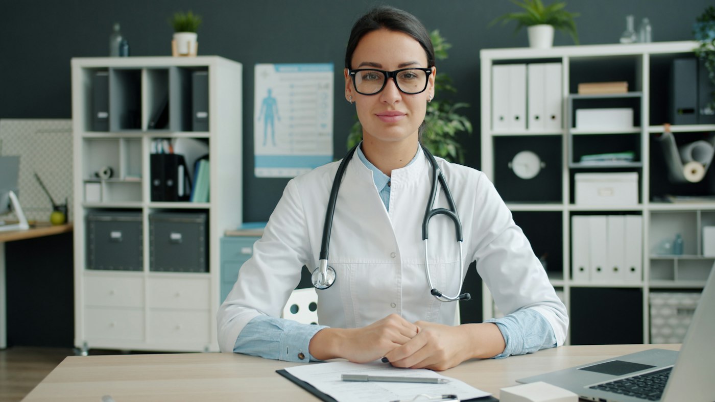 Médica sorrindo em seu consultório